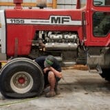 Joe Carr, during the evening of September 26, 2023, inflates the front tire of one of the main tractors he uses on his family's farm.
